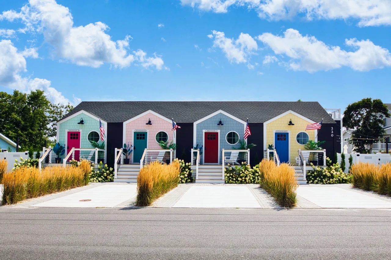 The completed Coastal Quad with four pastel cottage entrances and landscaped front gardens.